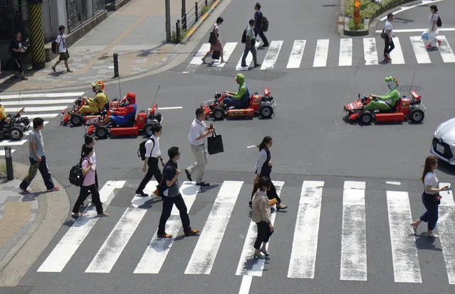 In this Monday, August 6, 2018, file photo, tourists from Wales drive carts on a street in Akihabara shopping and tourist district, in Tokyo. Nintendo says it has won damages in a lawsuit against a Tokyo business that has been renting go-karts for people to drive around the city in Super Mario costumes. (Photo by Eugene Hoshiko/AP Photo)