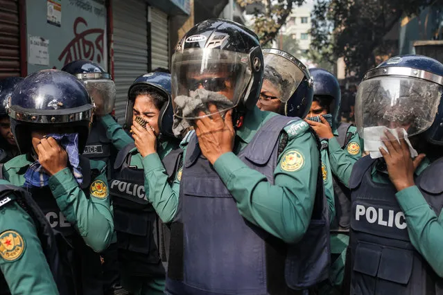 Counter terrorism unit of Police hold their nose after the suicidal vest explosion by the militants at Ashkona in Dhaka, Bangladesh on December 24, 2016. Two female militants along with two children surrendered to the cops, 1 female and a teen militant killed themselves during police raid by exploding suicidal vest outside their den while acting to surrender to the cops. (Photo by Anik Rahman/NurPhoto via Getty Images)