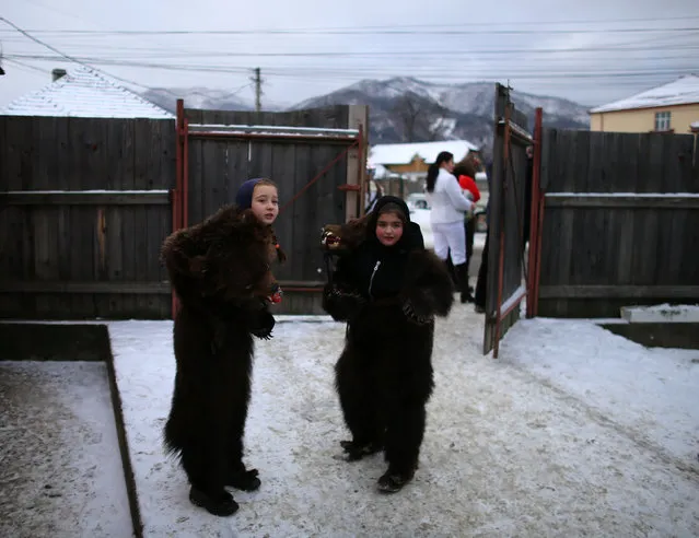 Children wearing costumes made of bearskins prepare for a festival in the village of Asau, Romania December 30, 2016. (Photo by Stoyan Nenov/Reuters)