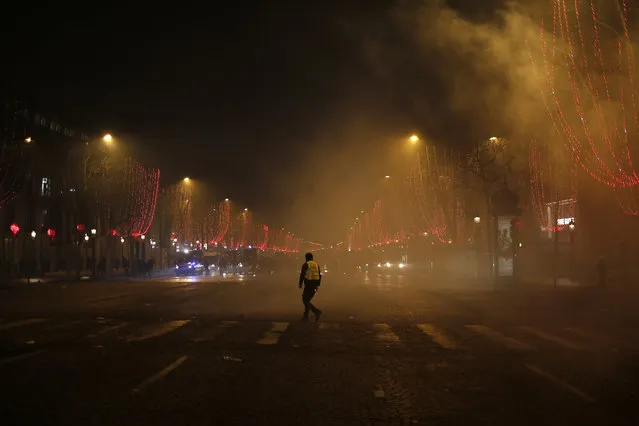 A lone demonstrator walks on the Champs-Elysees avenue Saturday, December 8, 2018 in Paris. (Photo by Rafael Yaghobzadeh/AP Photo)