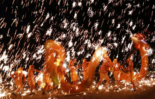 Artists perform a dragon dance under a shower of sparks from molten iron to celebrate the new year in Suining, Sichuan province, China December 31, 2016. (Photo by Reuters/Stringer)