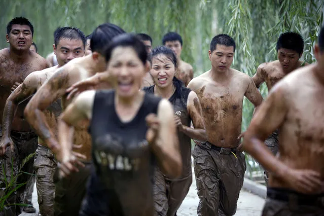 Female and male trainees run during a bodyguard training program at the boot camp of Genghis Security Academy in Beijing, China. (Photo by ImagineChina/The Grosby Group)