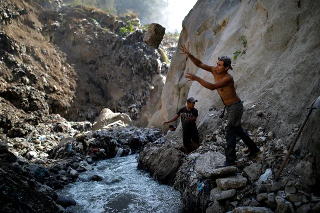 A man removes a rock as he searches for scrap metal at an area known as “the Mine”, in the largest garbage dump of Guatemala City, in Guatemala December 27, 2018. (Photo by Carlos Barria/Reuters)