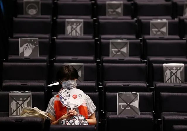 A woman reacts as she watches live broadcasting of volleyball match between Japan and Poland on a large screen during a public viewing event for Tokyo 2020 Olympic Games at a theatre in Takasaki, Gunma Prefecture, Japan, July 30, 2021. (Photo by Kim Kyung-Hoon/Reuters)