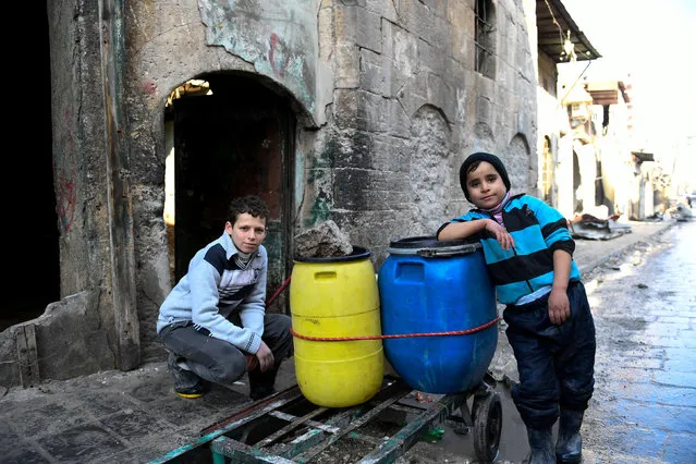 Boys are pictured beside a cart they use to carry water back to their home in the east Aleppo neighborhood of al-Mashatiyeh, Syria, in this handout picture provided by UNHCR on January 4, 2017. (Photo by Bassam Diab/Reuters)