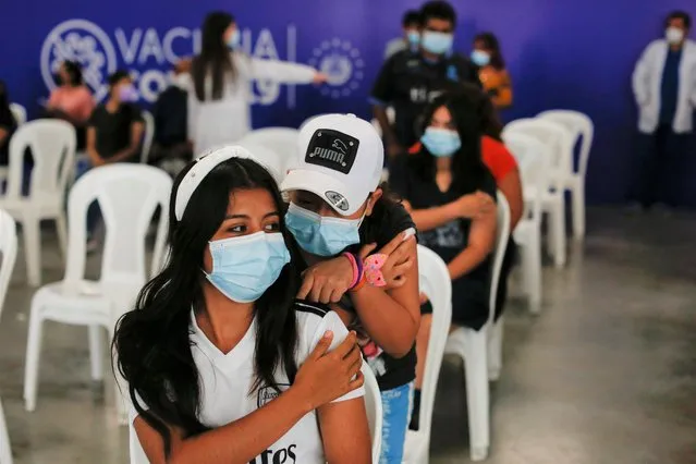 Daniela Gonzalez (17) talks with her sister Ashley Gonzalez (12) as they wait in an observation room after receiving their first dose of the coronavirus disease (COVID-19) vaccine at Hospital El Salvador vaccination center in San Salvador, El Salvador, August 11, 2021. (Photo by Jose Cabezas/Reuters)