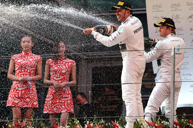 British Formula One driver Lewis Hamilton (C) celebrates with second placed German Formula One driver Nico Rosberg (R) of Mercedes AMG GP after winning the Chinese Formula One Grand Prix at the Shanghai International circuit in Shanghai, China, 12 April 2015. (Photo by Wu Hong/EPA)