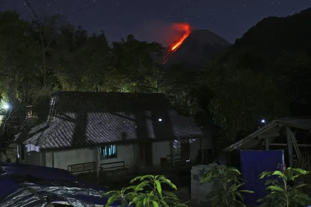 In this photo taken using slow camera shutter speed, hot lava runs down from the crater of Mount Merapi, in Sleman, Yogyakarta, Indonesia, early Wednesday, August 11, 2021. The volcano is the most volatile of more than 120 active volcanoes in the country, and is one of the most active worldwide. (Photo by Trisnadi/AP Photo)