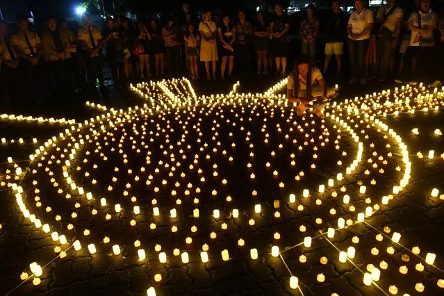 People place LED candles during a vigil in memory of Super Typhoon Haiyan victims on the tenth anniversary of the disaster at a park in Tacloban city, Leyte province, on November 8, 2023. Survivors of Super Typhoon Haiyan prayed for their dead loved ones in the devoutly Catholic Philippines on November 8 as they commemorated the 10th anniversary of a storm that killed more than 6,000 people. (Photo by Ted Aljibe/AFP Photo)