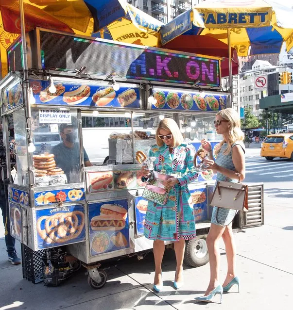 Hilton hotels heiresses Paris Hilton and Nicky Hilton Rothschild buy pretzels from a stand on their way to New York Fashion Week in New York on September 10, 2021. (Photo by Chelsea Lauren/Rex Features/Shutterstock)