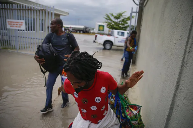 Haitians deported from the United States leave Toussaint Louverture International Airport under a rain shower in Port au Prince, Haiti, Sunday, September 19, 2021. (Photo by Joseph Odelyn/AP Photo)