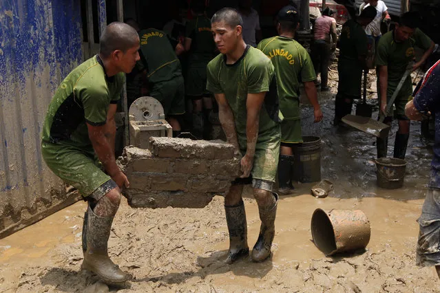 Peruvian military soldiers help remove mud from affected houses after a landslide and a flood occurred in San Juan de Lurigancho distritct, in Lima, Peru February 1, 2017. (Photo by Guadalupe Pardo/Reuters)