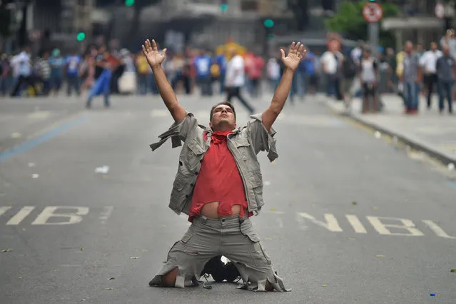 A protester surrenders to riot police during a protes against austerity measures in front of the Rio de Janeiro State Legislative Assembly in Rio de Janeiro, Brazil, on February 1, 2017. (Photo by Fabio Teixeira/Anadolu Agency/Getty Images)