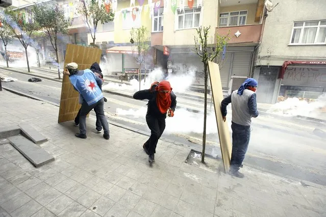 Protesters take cover as they clash with police near Taksim Square in Istanbul, Turkey, May 1, 2015. (Photo by Huseyin Aldemir/Reuters)