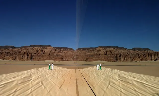 This handout picture obtained from the Royal Commission for Al-Ula, shows people standing in front of the Maraya (Mirror), the world's largest mirrored building, in the desert canyon of Ashar Valley in Saudi Arabia's northwestern Al-Ula desert, on January 28, 2024. (Photo by Patrick Baz/Royal Commission for Al-Ula via AFP Photo)