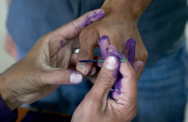 A polling officer marks the thumb of a voter with indelible ink at a polling station, during general elections in Karachi, Pakistan, 08 February 2024. Pakistani voters headed to heavily guarded polling stations on 08 February, to elect a new government for a five-year term amid increased security threats. According to the election body, the polling started at 8 a.m. local time and will continue until 5 p.m. The counting of millions of votes cast will start soon after polling time is over. There are more than 128 million registered voters, 59.3 million (46 percent) women and 69.2 million or 54 percent men. More than 20 million new voters have been registered for the 2024 elections. There are nearly 18,000 candidates out of whom 5,112 including 4797 males, 313 women, and two transgender contestants, running for 266 contestable parliamentary seats. (Photo by Rehan Khan/EPA/EFE)