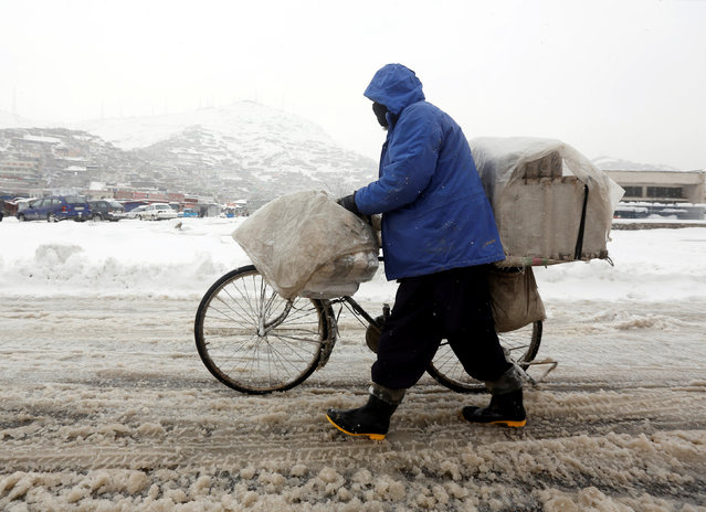 An Afghan man pushes his bicycle on a snowy day in Kabul, Afghanistan February 5, 2017. (Photo by Omar Sobhani/Reuters)