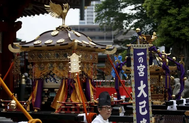 A Shinto priest walks past Horens, portable shrines, during a ritual for the Kanda festival at the Kanda-Myojin shrine in Tokyo May 9, 2015. (Photo by Toru Hanai/Reuters)