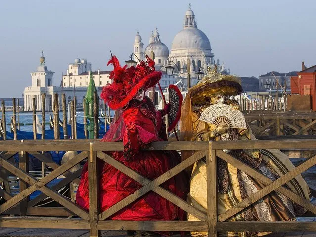 Two women dressed in Carnival Costumes pose in Saint Mark's Square on February 25, 2014 in Venice, Italy. The 2014 Carnival of Venice will run from February 15 to March 4 and includes a program of gala dinners, parades, dances, masked balls and music events. (Photo by Marco Secchi/Getty Images)