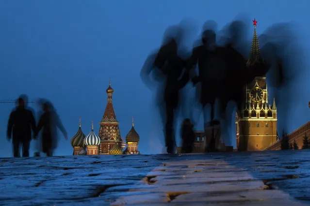 People walk through Red Square after sunset in Moscow, Russia, March 3, 2019, with the St. Basil's background left, and the Spasskaya Tower, right, in the background. (Photo: Alexander Zemlianichenko/AP)