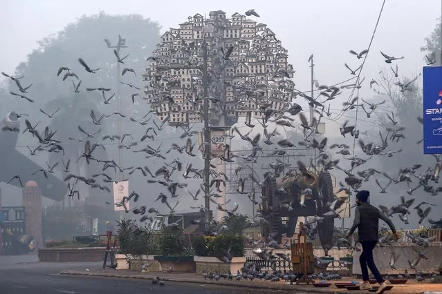 A man walks along a road amid smoggy conditions in Lahore on November 30, 2021. (Photo by Arif Ali/AFP Photo)