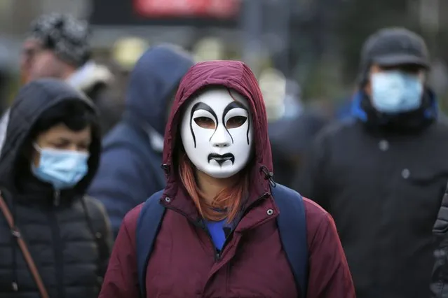 A protestor wears a mask while blocking the streets in front of the government headquarters during a protest against Rio Tinto's plans to open a lithium mine in Belgrade, Serbia, 18 December 2021. Rio Tinto Group, a multinational and the world's second-largest metals and mining corporation, has had its plans to open a lithium mine in Serbia halted after environmental groups stared protesting against the companies project. (Photo by Andrej Cukic/EPA/EFE)