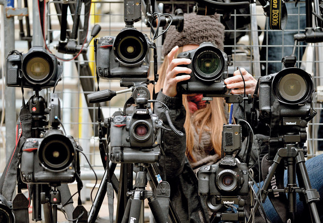 A photographer adjusts a camera as media wait outside 11 Downing Street, the official London residence of the Chancellor of the Exchequer, ahead of George Osborne's Budget speech in the House of Commons, on March 19, 2014. (Photo by Anthony Devlin/PA Wire)