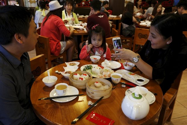 A family takes pictures as they dine in a Hello Kitty-themed Chinese restaurant in Hong Kong, China May 21, 2015. (Photo by Bobby Yip/Reuters)