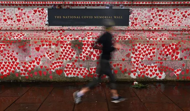 A jogger runs past the Covid-19 Memorial Wall in London, Britain, 27 December 2021. The UK government is expected to announce if further Covid restrictions will be required to curb the spread of the Omicron variant. British Prime Minister Boris Johnson is to receive new data from scientists. Pubs and restaurants are most at risk if further restrictions are implemented. (Photo by Andy Rain/EPA/EFE)