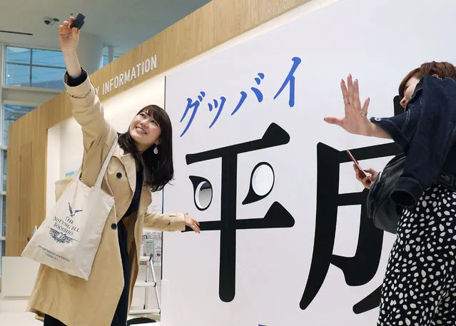 Visitors take a selfie with a panel with “Good-bye Heisei” written in Japanese at Fukuoka Tower in Fukuoka, southwestern Japan, Tuesday, April 30, 2019. Japan's Emperor Akihito is set to abdicate later in the day as Japan embraces the end of his reign with an emotion mixed with reminiscence and hopes for a new era. (Photo by Miyuki Saito/Kyodo News via AP Photo)