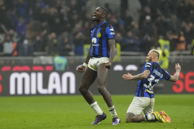 Inter Milan's Marcus Thuram, left, and Inter Milan's Federico Dimarco celebrate at the end of the Serie A soccer match between AC Milan and Inter Milan at the San Siro stadium in Milan, Italy, Monday, April 22, 2024. (Photo by Luca Bruno/AP Photo)