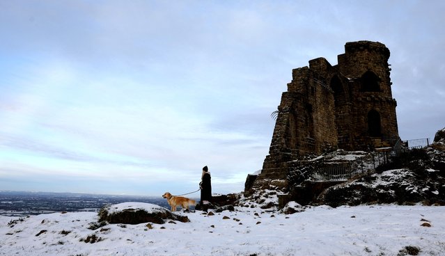 A woman walks her dog next to Mow Cop Castle, Mow Cop, Staffordshire, Britain on January 16, 2024. (Photo by Carl Recine/Reuters)