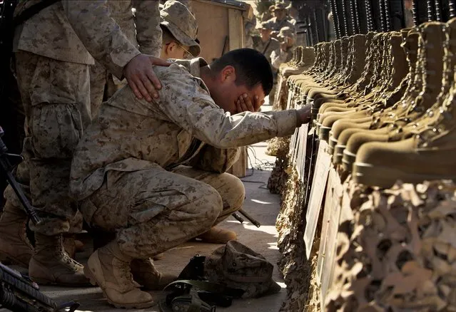 A U.S. Marine cries during the memorial service for 31 killed U.S. servicemen at Camp Korean Village, near Rutbah, western Iraq, Feb. 2, 2005. (Photo by Anja Niedringhaus/AP Photo)