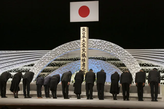 Bereaved family members bow in front of the altar for the victims of the March 11, 2011 earthquake and tsunami during the national memorial service in Tokyo Saturday, March 11, 2017. Japan marked on Saturday the sixth anniversary of the 2011 disaster in which more than 18,000 people died or went missing. (Photo by Koji Sasahara/AP Photo)