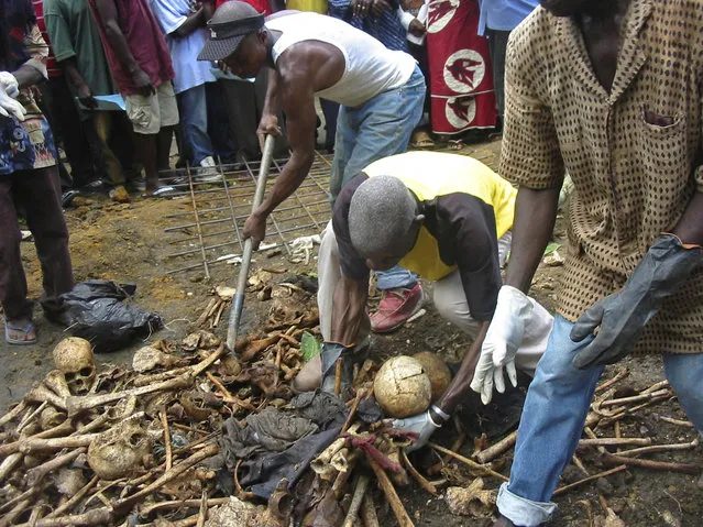 This is a Saturday, September 5, 2009, file photo of  people as they  clear bones and skulls that were on display in Kpolokpai, Liberia. The remains of hundreds of people killed 15 years ago near a Liberian village are being reburied in a mass grave with a ceremony marking the massacre. Kpolokpai massacre, one of many chapters in Liberia's civil war that killed an estimated 250,000 people between 1989 and 2003. (Photo by Jonathan Paye-Layleh/AP Photo)