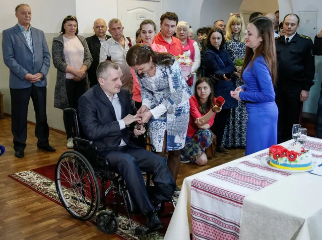 Alexander Darmoros (L), a Ukrainian serviceman who was wounded during fighting with pro-Russian rebels in the country's eastern regions, and his bride Elena attend their wedding ceremony in the central military hospital in Kiev, Ukraine, May 5, 2016. (Photo by Gleb Garanich/Reuters)