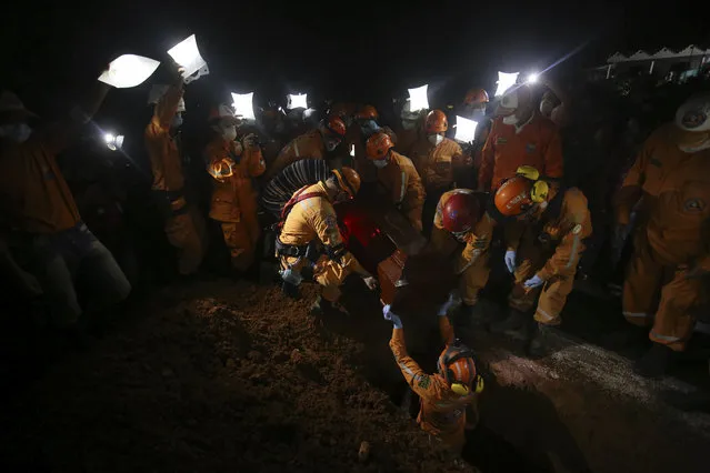 Rescue workers bury their comrade Jesus Diago, who was killed while rescuing his family, in Mocoa, Colombia, Tuesday, April 4, 2017. Diago was killed when surging rivers sent an avalanche of floodwaters, mud and debris sweeping him away as he attempted to carry a cousin to safety. He had already managed to save the rest of his family and the young cousin was the last one to be rescued when they were both swept away and killed. (Photo by Ivan Valencia/AP Photo)