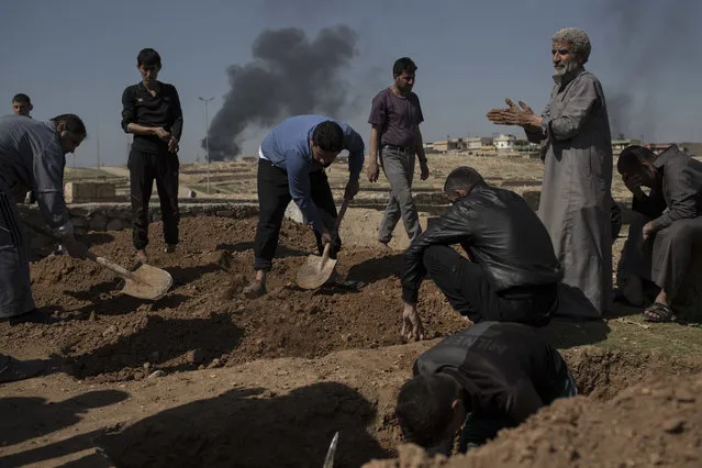 Relatives and friends bury the body of Khadeer Hassan, who was killed during fighting between Iraqi security forces and Islamic State militants, on the western side of Mosul, Iraq, Saturday, March 25, 2017. (Photo by Felipe Dana/AP Photo)