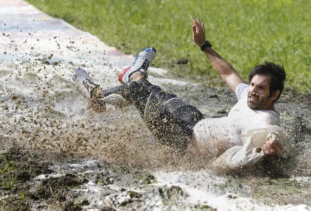 A participant of an obstacle extreme run “Bison race” slips in mud while carrying a heavy sack with sand in Logoisk, 40 km from Minsk, Belarus, 08 May 2016. “Bison race” is a run with various natural and artificial challenging obstacles, that is held on 07 and 08 May. (Photo by Tatyana Zenkovich/EPA)
