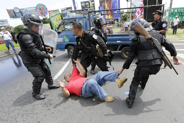 Riot policemen detain an opposition supporter during a protest in front of the Supreme Electoral Council (CSE) building in Managua, Nicaragua July 8, 2015. The protesters were demonstrating to demand for what they call fairer elections in the country next year. (Photo by Reuters/Stringer)