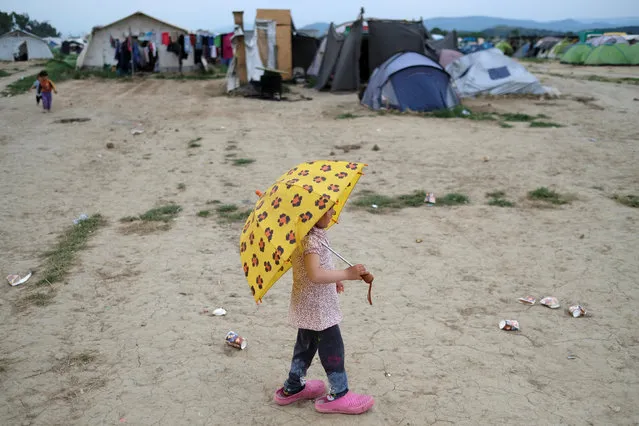 A girl holds an umbrella at a makeshift camp for migrants and refugees at the Greek-Macedonian border near the village of Idomeni, Greece, May 10, 2016. (Photo by Marko Djurica/Reuters)