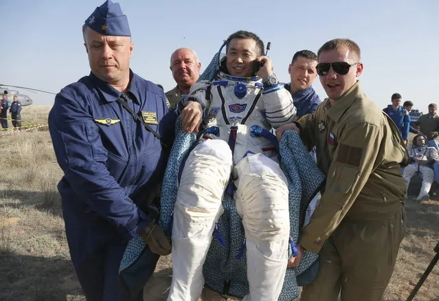 A Russian space agency rescue team members carries Japanese astronaut Koichi Wakata shortly after the landing of the Russian Soyuz TMA-11 space capsule about 150 kilometers (93 miles) southeast of the Kazakh town of Dzhezkazgan, Kazakhstan, Wednesday, May 14, 2014. The Soyuz space capsule with Wakata, Russian cosmonaut Mikhail Tyurin and U.S. astronaut Rick Mastracchio, returning from a half-year mission to the International Space Station landed safely Wednesday on the steppes of Kazakhstan. (Photo by Dmitry Lovetsky/AP Photo)