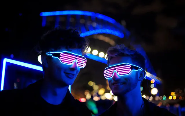 Visitors to first night of the Sydney Vivid Festival of light and sound wear illuminated novelty sunglasses alongside the Sydney Harbour Bridge in Sydney, Australia May 26, 2017. (Photo by Jason Reed/Reuters)