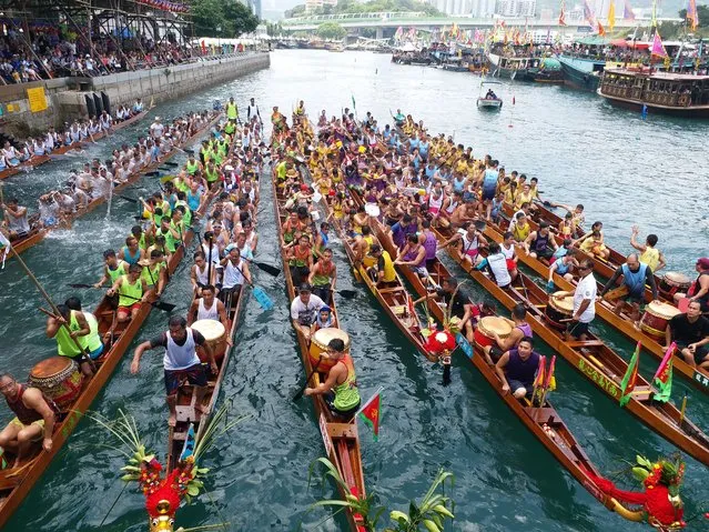 Participants compete in a dragon boat race held to celebrate the Dragon Boat Festival, also known as Duanwu Festival, in Aberdeen fishing harbor in Hong Kong, China, 30 May 2017. A dragon boat race was held in a Hong Kong on the Dragon Boat Festival (May 30). The race, involving over 60 boats, was organized in celebration of the Chinese Dragon Boat Festival. The Dragon Boat Festival, also named Duanwu Festival, falls on the fifth day of the fifth month in the Chinese lunar calendar in honor of Qu Yuan, an ancient Chinese poet and statesman. (Photo by Wang Qian/AFP Photo/Imaginechina)
