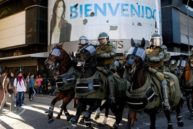 Riot policemen ride horses to disperse demonstrators during a protest against Chile's government in Concepcion, Chile on December 2, 2019. (Photo by Jose Luis Saavedra/Reuters)