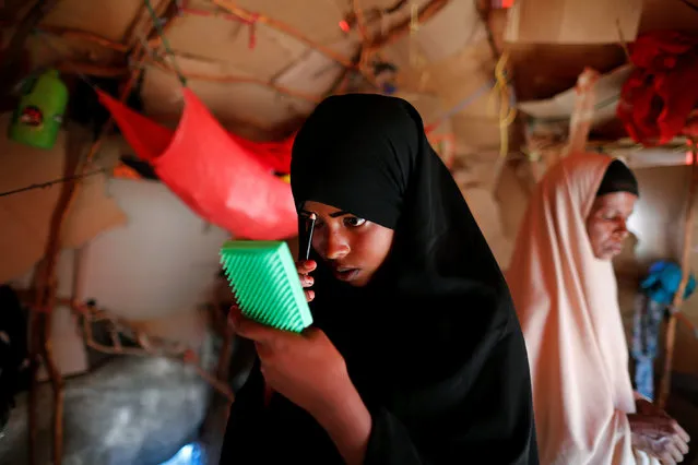 Zeinab, 14, applies her make-up before heading to school inside her shelter at a camp for internally displaced people from drought hit areas in Dollow, Somalia April 4, 2017. (Photo by Zohra Bensemra/Reuters)