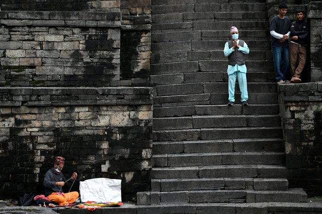 A Hindu priest prepares Rakshyabandhan, sacred threads, on the embankment of the holy Basmati river flowing next to Pashupatinath temple, as a devotee offers prayers to mark the Janai Purnima festival, for protection and purification, in Kathmandu, Nepal, on August 19, 2024. (Photo by Monika Malla/Reuters)