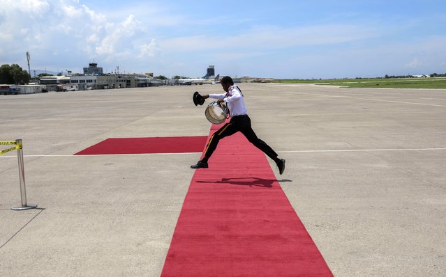 A member of the Police Music Band jumps over the welcome mat before the arrival of Kenya's President William Ruto at the Toussaint Louverture International Airport in Port-au-Prince, Haiti, Saturday, September 21, 2024. (Photo by Odelyn Joseph/AP Photo)