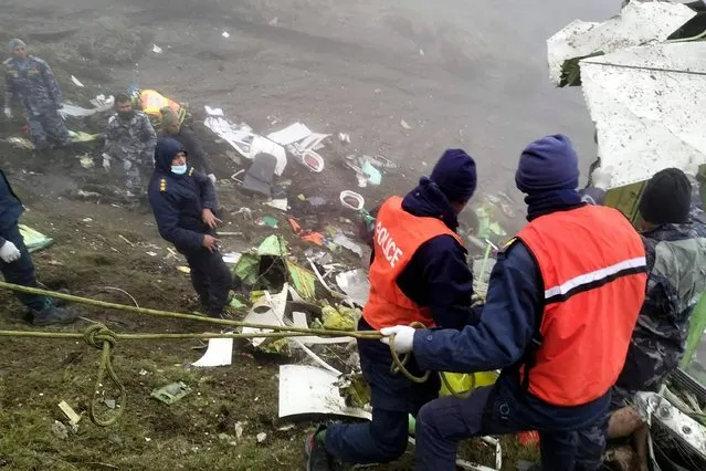 This handout photograph taken on May 30, 2022 and released by the Nepal Police shows members of a rescue team carrying out a operation at the crash site of a Twin Otter aircraft, operated by Nepali carrier Tara Air, on a mountainside in Mustang, a day after it crashed. Nepali rescuers on May 30 retrieved 16 bodies from the mangled wreckage of a passenger plane strewn across a mountainside that crashed in the Himalayas with 22 people on board. (Photo by Man Bahadur Basyal/Nepal Police/AFP Photo)