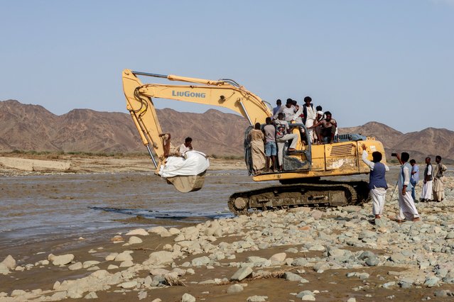 Aid and people are transported on an excavator following devastating floods, in Port Sudan, Sudan, on August 26, 2024. (Photo by El Tayeb Siddig/Reuters)